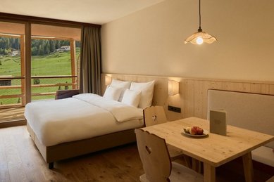 Helles Familienzimmer mit Balkon und Bergblick im Familienhotel Bella Vista in Südtirol.