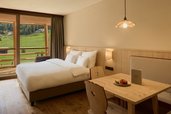 Helles Familienzimmer mit Balkon und Bergblick im Familienhotel Bella Vista in Südtirol.