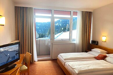 Das Familienzimmer "Geierkogel" mit Doppelzimmer, Schreibtisch und Balkon mit Blick auf die Skipiste im Hotel Alpengasthof Hochegger.