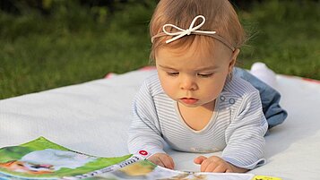 Ein Kleinkind schaut sich ein Bilderbuch an