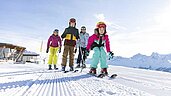 Familie auf der Piste beim Skifahren bei wundervollem Wetter in Tirol in der Nähe vom Adler Familien- & Wohlfühlhotel.