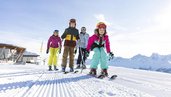 Familie auf der Piste beim Skifahren bei wundervollem Wetter in Tirol in der Nähe vom Adler Familien- & Wohlfühlhotel.