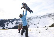 Winterlicher Familienspaß im Schnee beim Familienhotel Das Bayrischzell mit Blick auf die verschneiten Berge