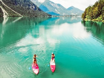 Zwei Stand-Up-Paddler auf dem Heiterwangersee in der Nähe des Familienhotels Kaiserhof in Berwang in der Tiroler Zugspitzarena