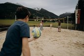 Beachvolleyballplatz beim Hotel Sonngastein im Salzburger Land mit spielenden Gästen und Blick auf die Berge.