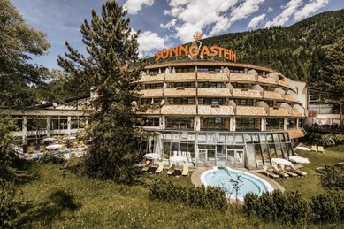Die Außenansicht des Hotel Sonngastein im Salzburger Land zeigt das Hotel mit Pool im Sommer.