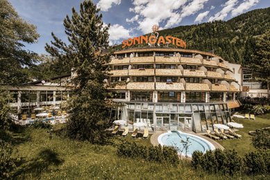 Die Außenansicht des Hotel Sonngastein im Salzburger Land zeigt das Hotel mit Pool im Sommer.