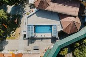 Der Poolbereich des Kinderhotels Bruckwirt in Oberösterreich ist in einer Drohnenaufnahme von oben zu sehen.