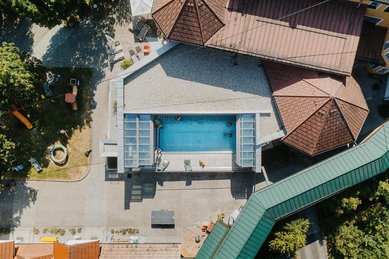 Der Poolbereich des Kinderhotels Bruckwirt in Oberösterreich ist in einer Drohnenaufnahme von oben zu sehen.
