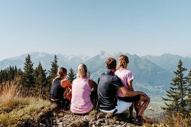 Familie genießt den Bergblick bei einer Wanderpause nahe dem Familienhotel Amiamo im Salzburger Land.
