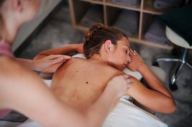 Frau entspannt bei einer wohltuenden Rückenmassage im Familien Resort Petschnighof in Kärnten.