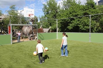 Kinder spielen auf dem Fußballfeld des Familienhotels Kinderhotel Stefan in Tirol Fußball.