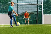 Zwei jugendliche Jungs spielen auf dem Fußballplatz des Elldus Resorts Fußball.