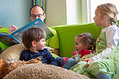 Betreuer liest Kinder ein Buch vor im Happy-Club im Familienhotel Mein Krug im Fichtelgebirge.