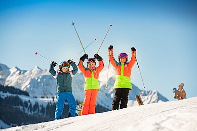 Drei glückliche Kinder auf der Skipiste na des Familienhotels Hotel Spa- & Familien-Resort Krone im Allgäu.