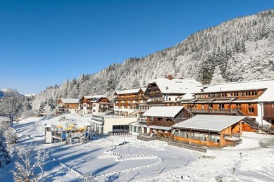 Winteransicht des verschneiten Familienhotels Ramsi in den Bergen mit direktem Zugang zur Natur.