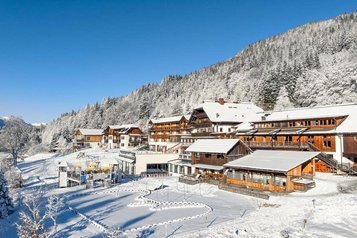 Winteransicht des verschneiten Familienhotels Ramsi in den Bergen mit direktem Zugang zur Natur.