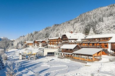 Winteransicht des verschneiten Familienhotels Ramsi in den Bergen mit direktem Zugang zur Natur.