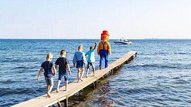 Kinder beim Strandausflug mit Maskottchen Happy im Familienhotel Strandkind an der Ostsee