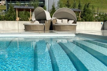 Blick auf den Infinity-Pool mit Liegeinseln im Familienhotel Bella Vista in Südtirol