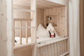 Ein Holzbett als Stockbett im Zimmer des Familienhotels Gorfion in Liechtenstein.