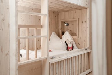 Ein Holzbett als Stockbett im Zimmer des Familienhotels Gorfion in Liechtenstein.