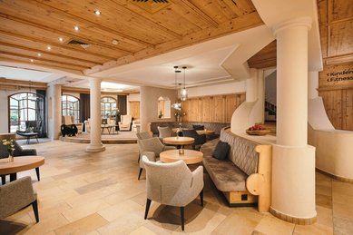 Gemütlich eingerichtete Lobby des Familienhotels Kindl mit modernen Sitzbereichen, viel Holz und warmem Licht