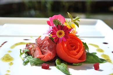 Frisches Abendessen fein dekoriert mit einer Rose im Restaurant Familienhotel Sonngastein in Bad GAstein.