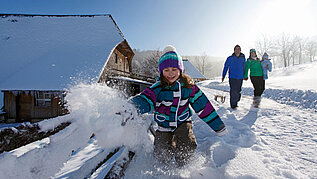 Spielendes Kind im Schnee im Schwarzwald-Familienurlaub.