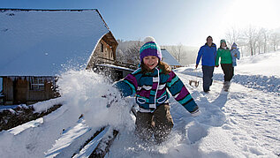 Spielendes Kind im Schnee im Schwarzwald-Familienurlaub.