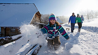 Spielendes Kind im Schnee im Schwarzwald-Familienurlaub.