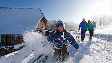 Spielendes Kind im Schnee im Schwarzwald-Familienurlaub.