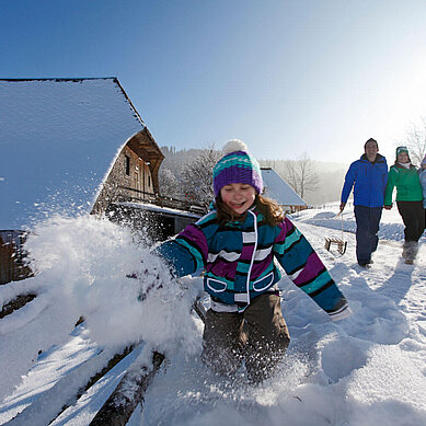 Spielendes Kind im Schnee im Schwarzwald-Familienurlaub.