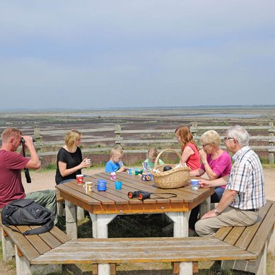 Eine Familie sitzt an einem Pichnicktisch im Dalum-Wietmarscher Moor.