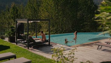 Familie genießt die Sonne und planscht im Außenpool des Familienhotels Engel Gourmet & Spa