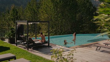 Familie genießt die Sonne und planscht im Außenpool des Familienhotels Engel Gourmet & Spa