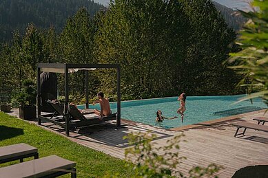 Familie genießt die Sonne und planscht im Außenpool des Familienhotels Engel Gourmet & Spa