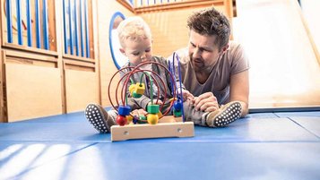 Ein Vater spielt mit seinem Baby in einem Familienhotel 