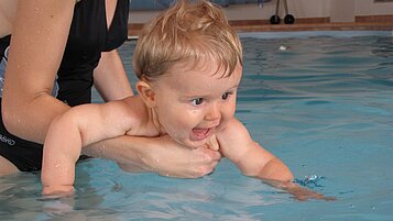 Mutter und Baby planschen gemeinsam im Pool.