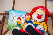 Maskottchen Happy als Kuscheltier mit Buch im Familienhotel Bruckwirt, das Kinder im Urlaub begleitet.