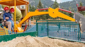 Vater und Tochter spielen auf dem Outdoor-Spielplatz vom Kaiserhof mit dem Bagger