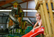 Mädchen auf der Rutsche im großen Indoorspielplatz des Familienhotels Sonnenhügel in der Rhön.