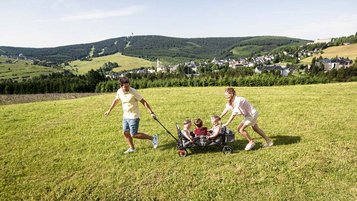 Auf einem Ausflug ins Grüne genießen Eltern mit Kindern die gemeinsame Zeit im Familienhotel.