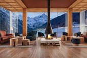 Gemuetliche Lounge mit Kamin, Sesseln und grossen Panoramafenstern mit Bergblick im Familienhotel Bella Vista in Suedtirol.