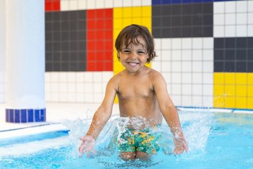 Junge planscht im gemütlichen Hallenbad vom Family Club Harz