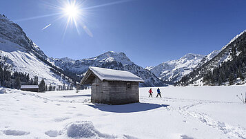 Zentral liegt ein Hütte zwischen Berggruppen. Eine tolle Landschafts für Familien im Winter in Tirol.