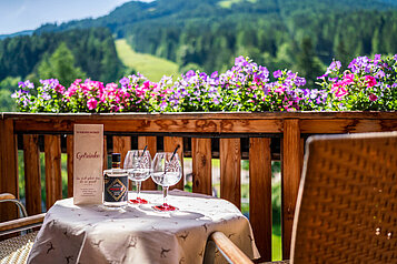 Tisch mit zwei Weingläsern auf dem Balkon des Familienhotels Kirchheimerhof in Kärnten.
