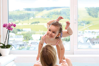 Mutter und Tochter entspannen im Whirlpool mit Blick auf die Landschaft im Familienhotel Sonnenpark.