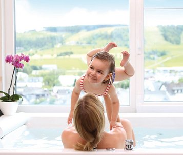 Mutter und Tochter entspannen im Whirlpool mit Blick auf die Landschaft im Familienhotel Sonnenpark.