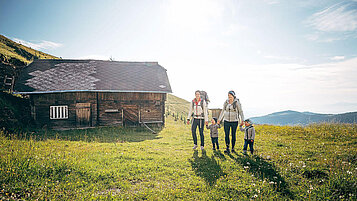 Zwei Mütter mit zwei Kleinkindern beim Wandern in den Nockbergen in Kärnten.